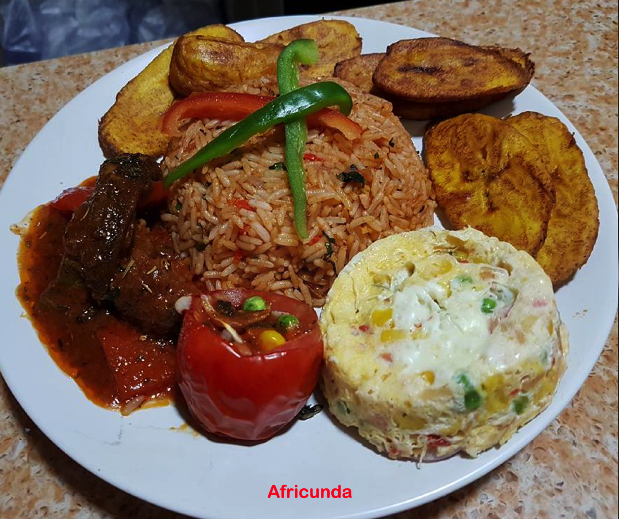 Africunda Style Jollof Rice with grilled & stuffed tomato, egg moi moi and a choice of meat or fish